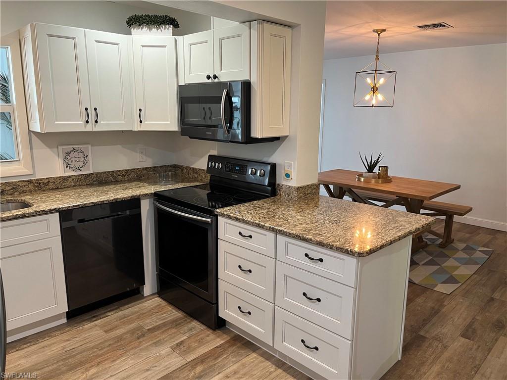 6730 Sable Ridge Lane Naples, FL 34109 - Photo 9 of 27 a kitchen with stainless steel appliances granite countertop a stove a sink and a microwave
