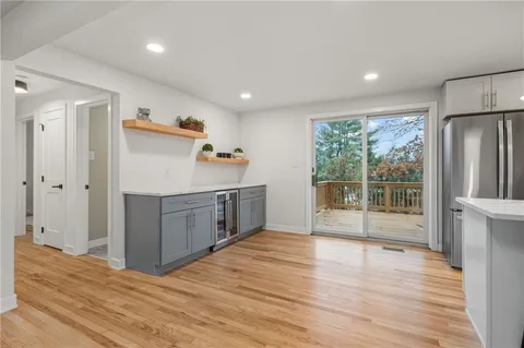 a view of a kitchen with wooden floor and electronic appliances
