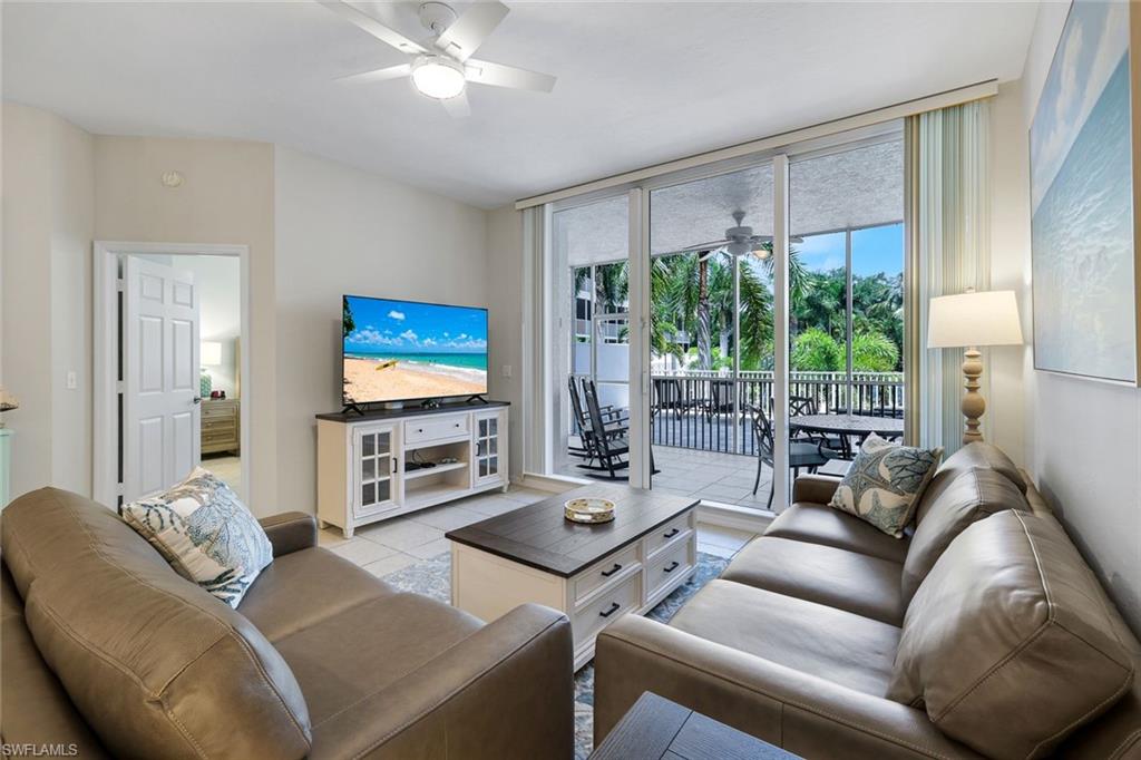 460 Launch Circle, Unit 202 Naples, FL 34108 - Photo 3 of 34 a living room with furniture and a flat screen tv