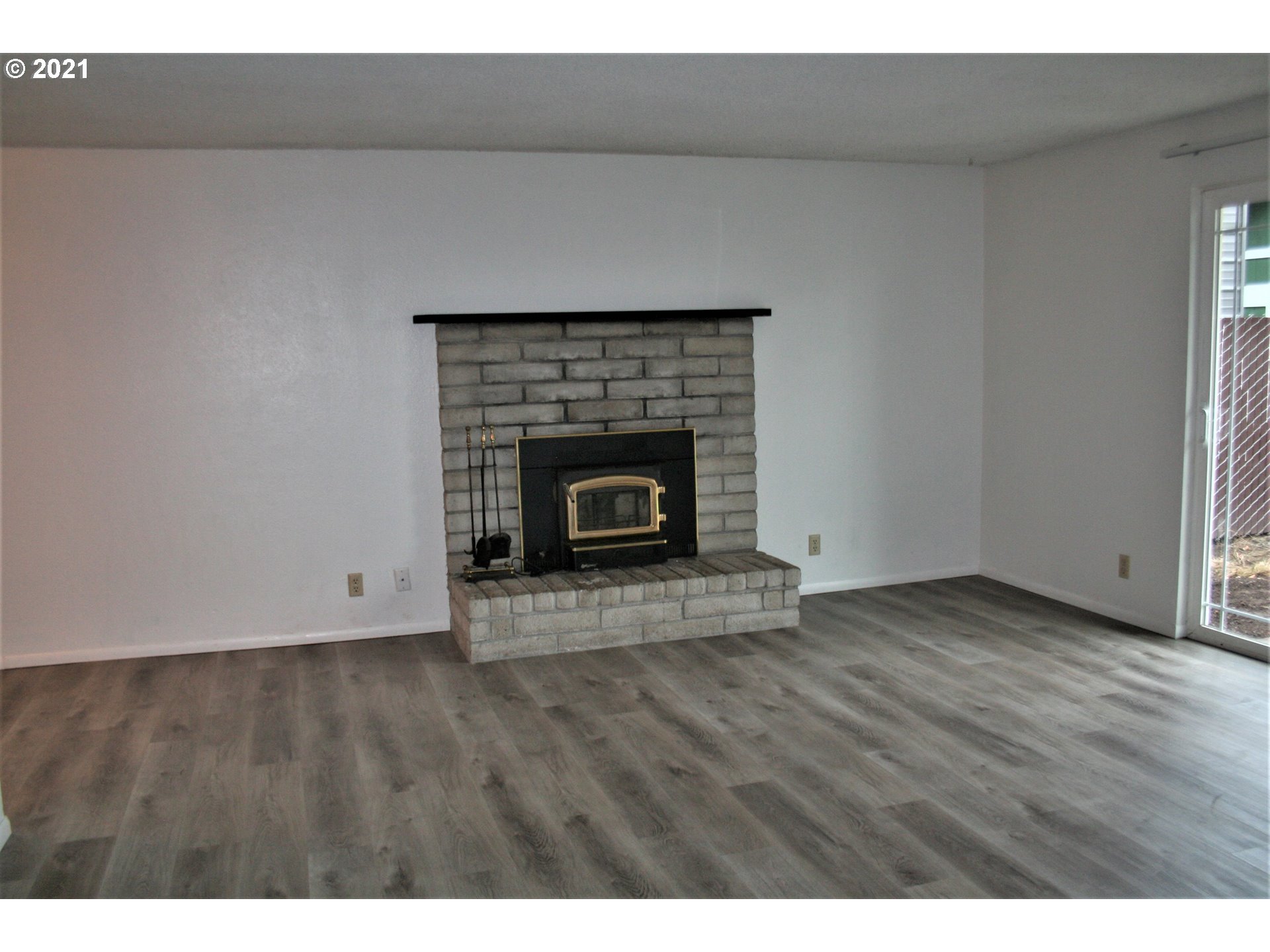 1167 T Street Springfield, OR 97477 - Photo 3 of 16 a view of an empty room with wooden floor and a fireplace