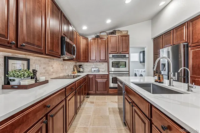 a kitchen with kitchen island granite countertop a sink stainless steel appliances and cabinets