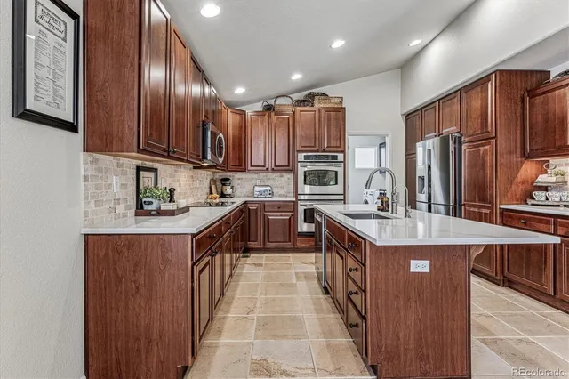a large kitchen with stainless steel appliances granite countertop a stove a sink dishwasher and a refrigerator