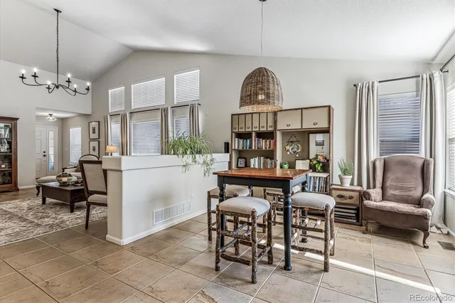 a living room with furniture a dining table and a chandelier