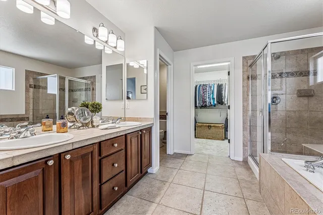 a spacious bathroom with a double vanity sink a large mirror and a shower