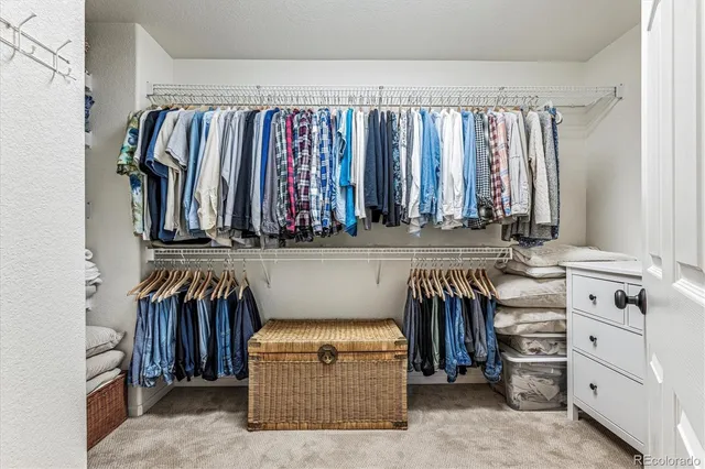 a view of walk in closet with clothes and shoes