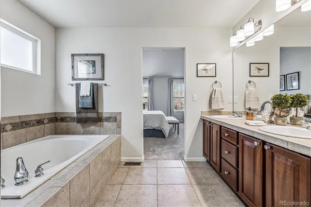 a spacious bathroom with a tub double sink and mirrors