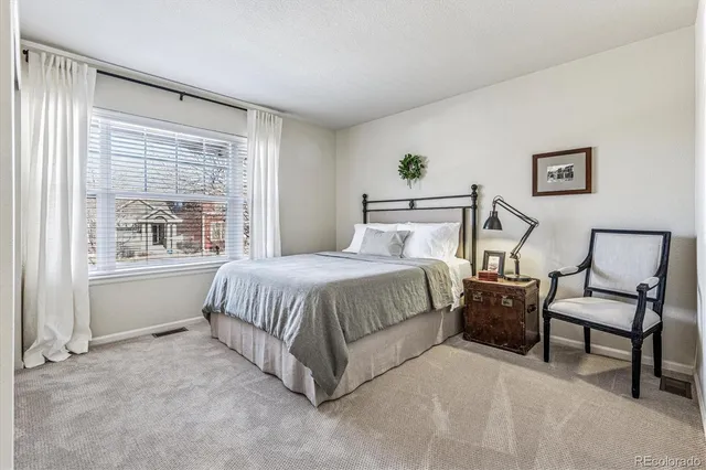 a bedroom with a bed chair and window
