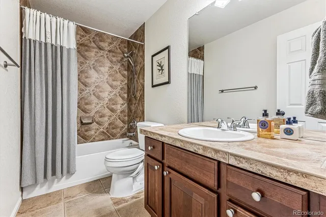 a bathroom with a granite countertop sink toilet and mirror