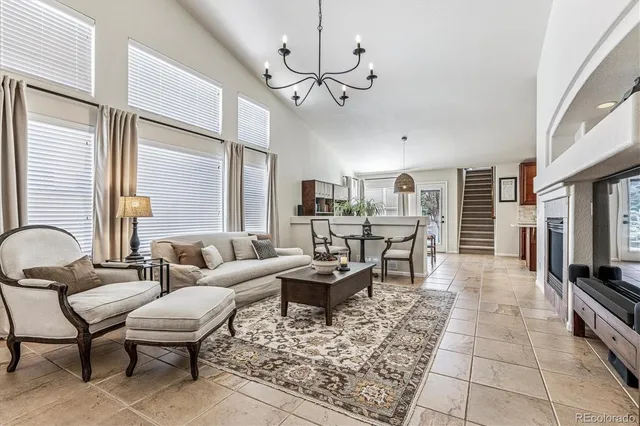 a living room with furniture a flat screen tv and a table