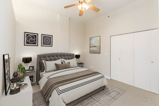 910 West Madison Street, Unit 703 Chicago, IL 60607 - Photo 12 of 23 a bedroom with a large bed and a chandelier