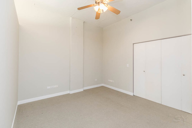 910 West Madison Street, Unit 703 Chicago, IL 60607 - Photo 13 of 23 an empty room with a chandelier fan