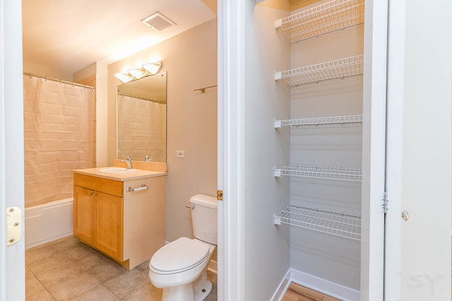 910 West Madison Street, Unit 703 Chicago, IL 60607 - Photo 17 of 23 a bathroom with a granite countertop toilet sink and a mirror
