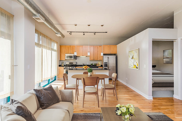 910 West Madison Street, Unit 703 Chicago, IL 60607 - Photo 6 of 23 a living room with stainless steel appliances kitchen island granite countertop furniture and a large window