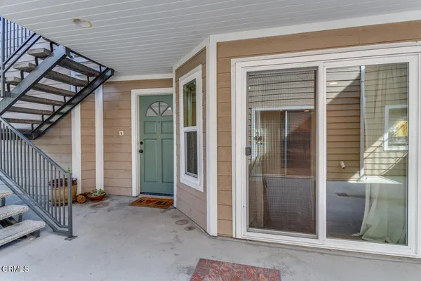 a view of a porch with a door and wooden floor