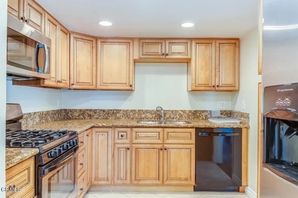 a kitchen with stainless steel appliances granite countertop a stove and a microwave
