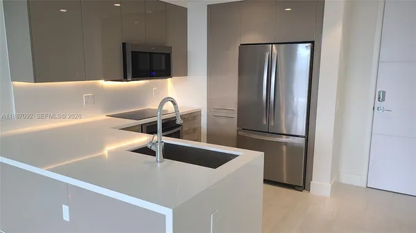 a kitchen with a refrigerator and a sink