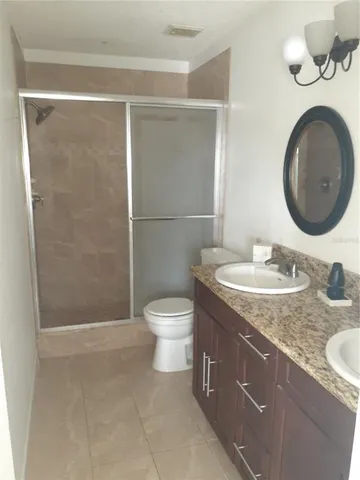 a bathroom with a granite countertop sink toilet and a mirror
