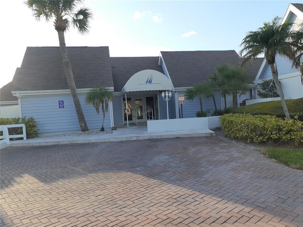 455 Alt 19, Unit 16 Palm Harbor, FL 34683 - Photo 19 of 25 a backyard of a house with table and chairs under an umbrella