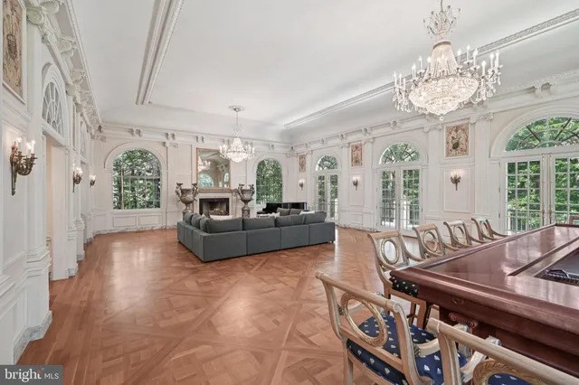 a living room with furniture a chandelier and a flat screen tv