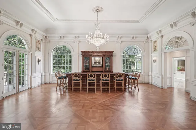 a living room with furniture a chandelier and a large mirror