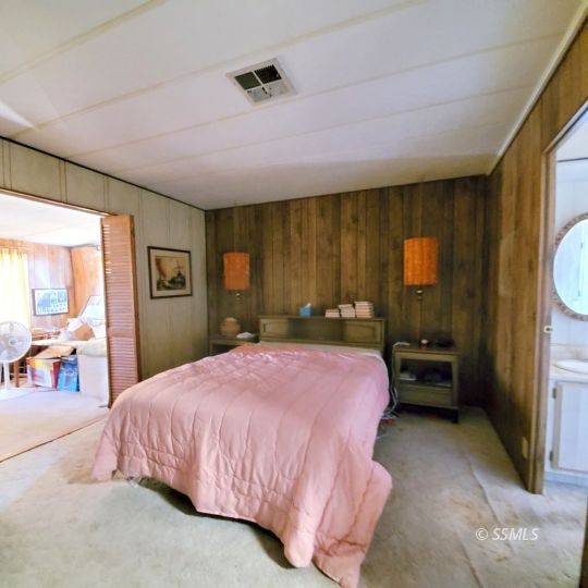 720 North Calvert Boulevard Ridgecrest, CA 93555 - Photo 13 of 24 a bedroom with a bed large window with table and chair