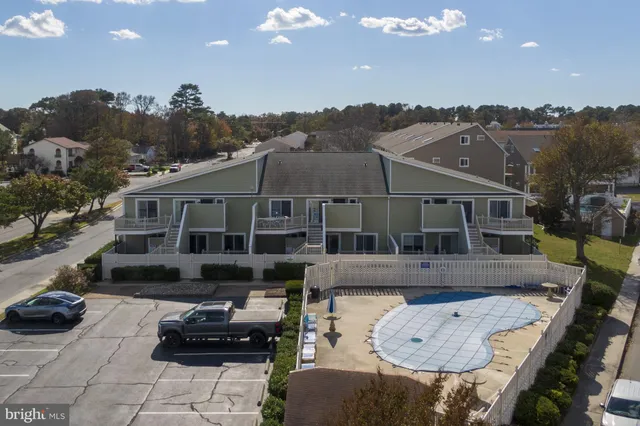 a front view of a house with cars parked