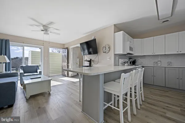 a kitchen with granite countertop a table chairs stove a sink dishwasher and cabinets with wooden floor