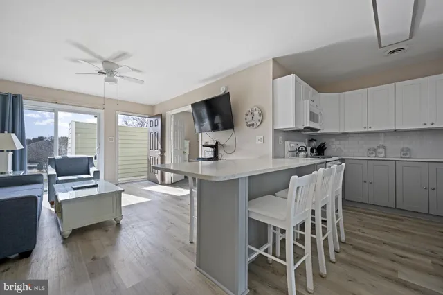 a kitchen with granite countertop a table chairs stove a sink dishwasher and cabinets with wooden floor