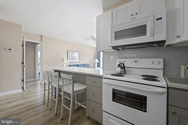 a kitchen with cabinets appliances and wooden floor