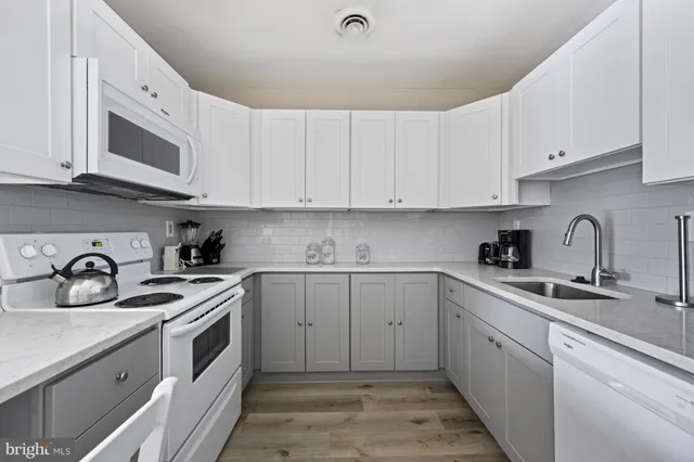a kitchen with stainless steel appliances granite countertop white cabinets a sink and dishwasher