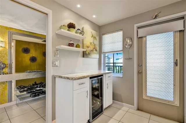 a kitchen with granite countertop white cabinets and refrigerator