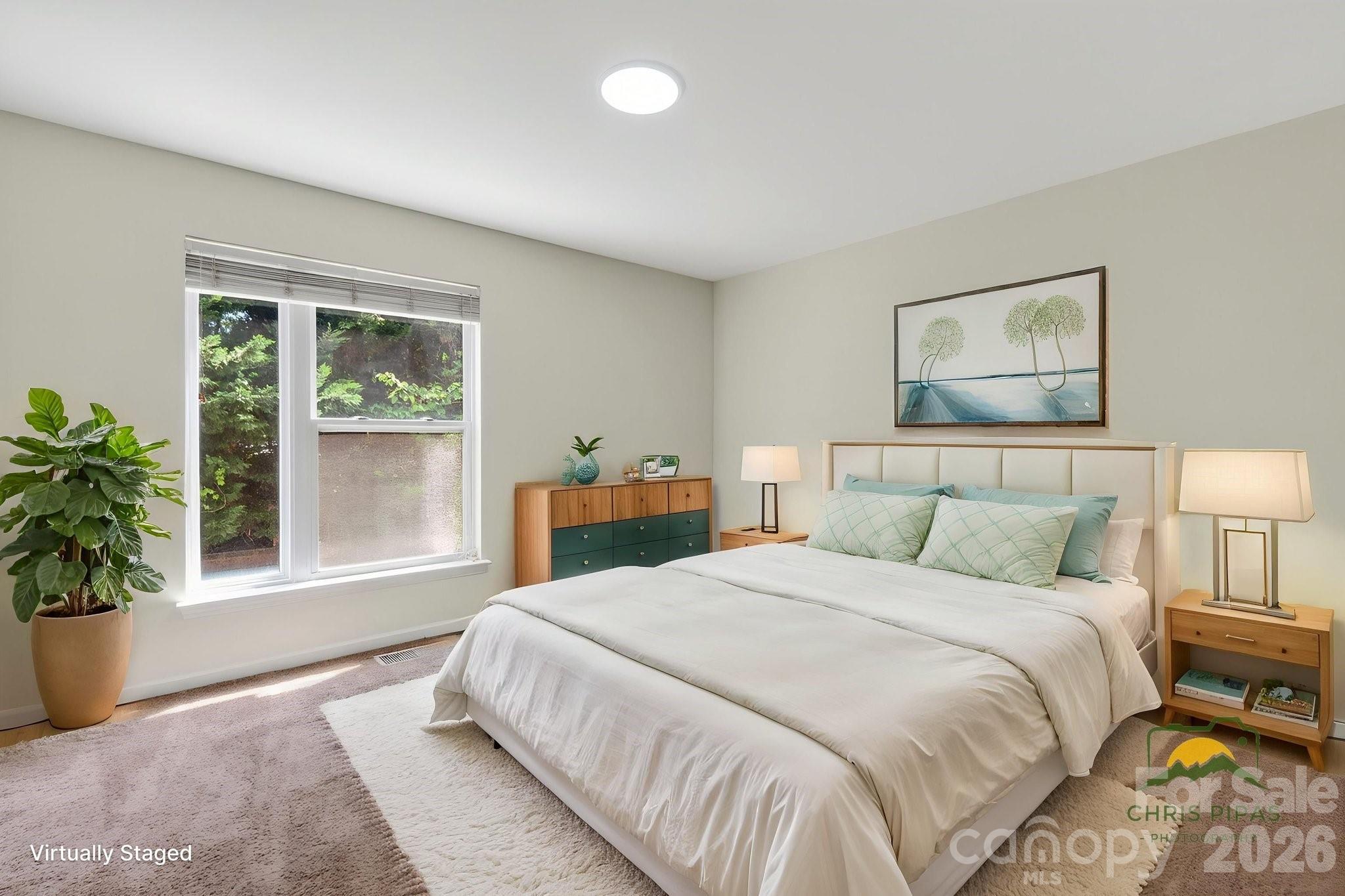 639 Raphael Place Charlotte, NC 28205 - Photo 18 of 36 a bedroom with a large bed and a potted plant
