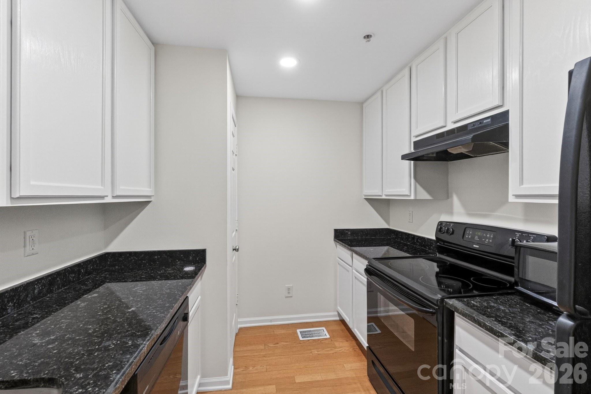 639 Raphael Place Charlotte, NC 28205 - Photo 7 of 36 a kitchen with granite countertop a stove sink and cabinets