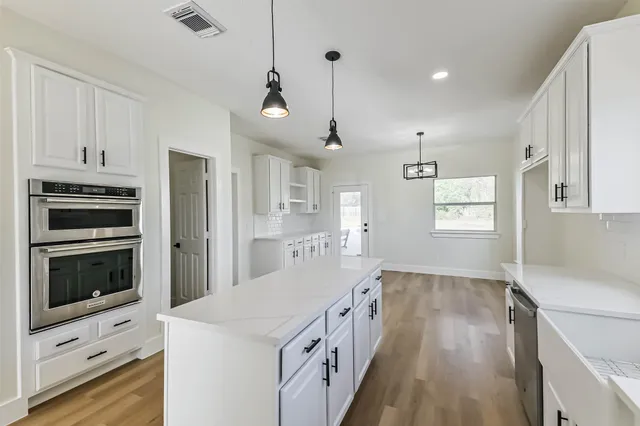 a kitchen with white cabinets and appliances