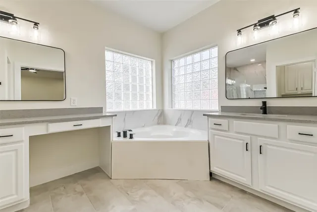 a bathroom with a double vanity sink mirror and shower