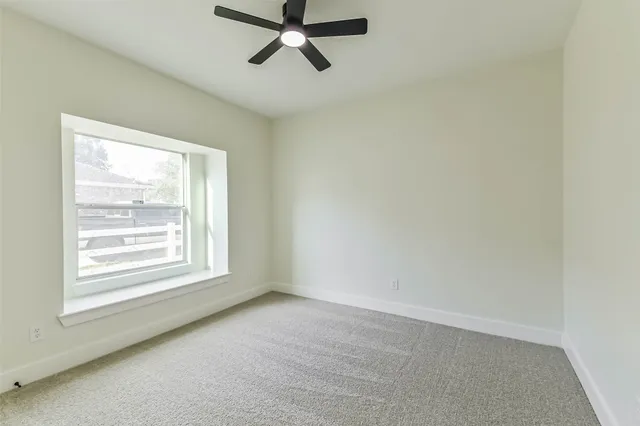 an empty room with chandelier fan