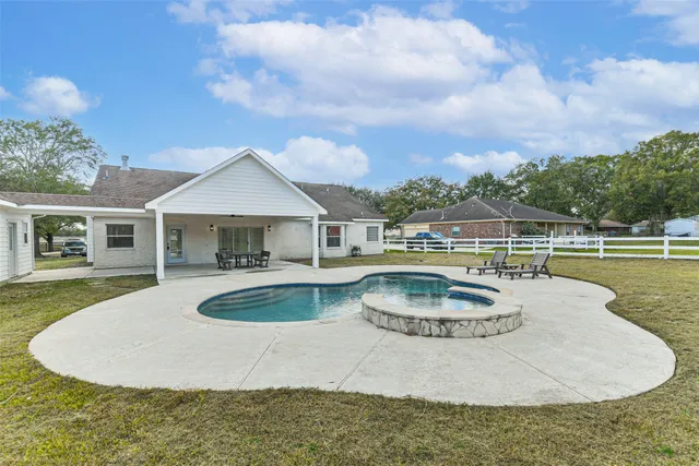 a swimming pool with outdoor seating and yard