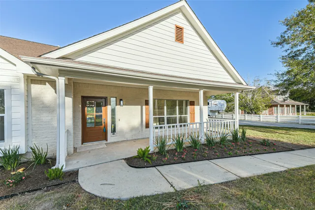 a view of a house with a small yard plants and large tree