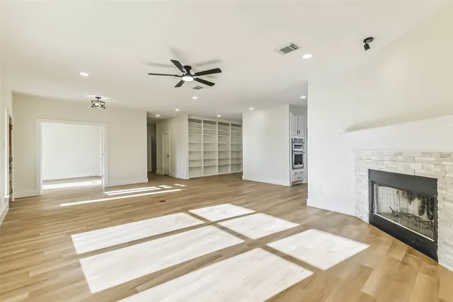 a view of an empty room with a fireplace and a window