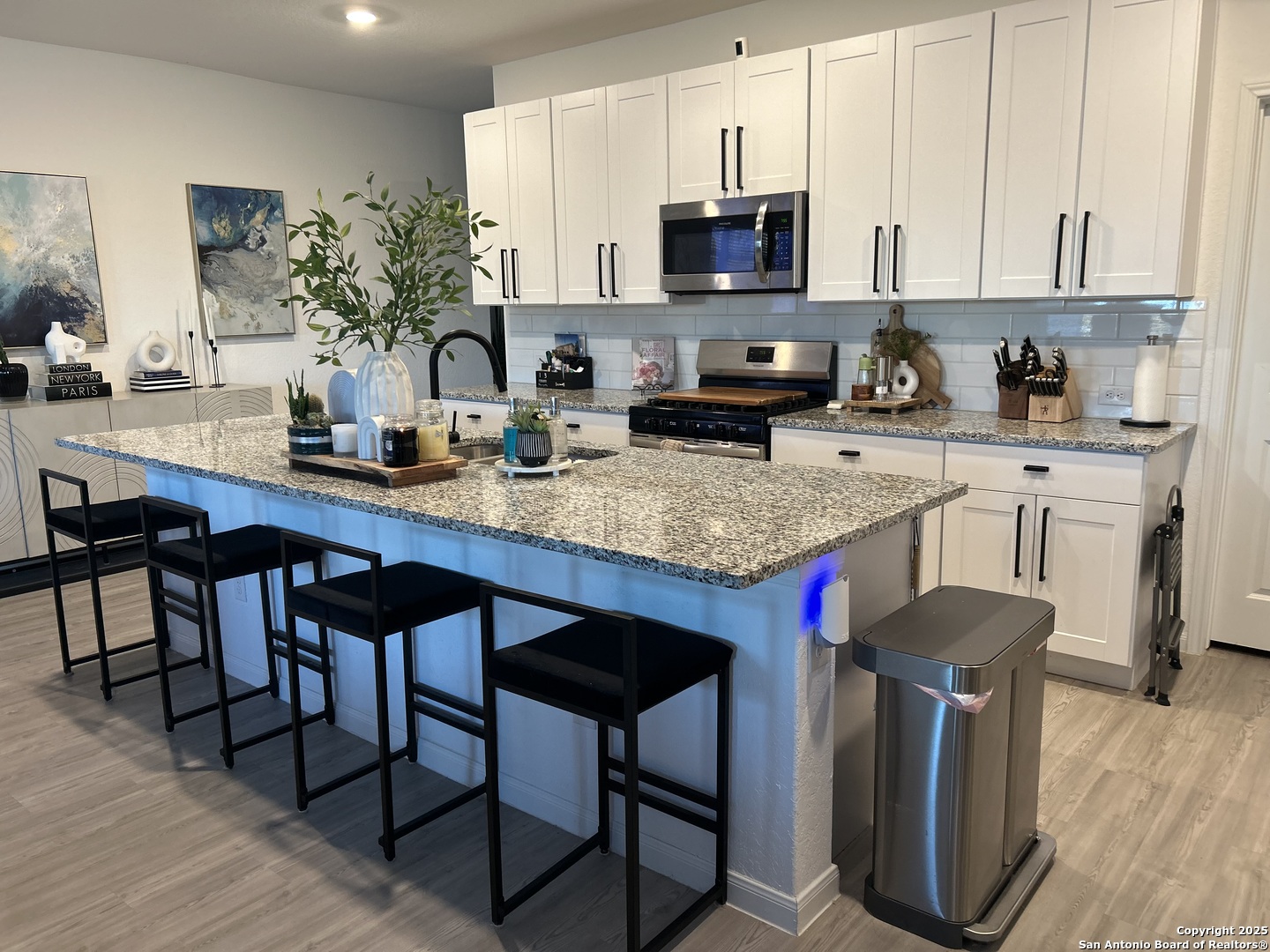 10127 Helios Heights Converse, TX 78109 - Photo 4 of 16 a kitchen with stainless steel appliances granite countertop a table chairs sink and cabinets