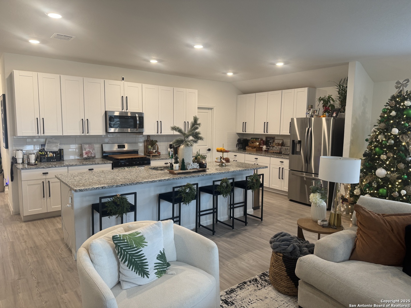 10127 Helios Heights Converse, TX 78109 - Photo 7 of 16 a living room with stainless steel appliances kitchen island granite countertop a kitchen island a couch a dining table and chairs