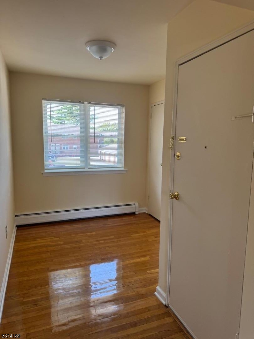 1298 Valley Road, Unit 1 Wayne, NJ 07470 - Photo 11 of 18 a view of an empty room with wooden floor and a window