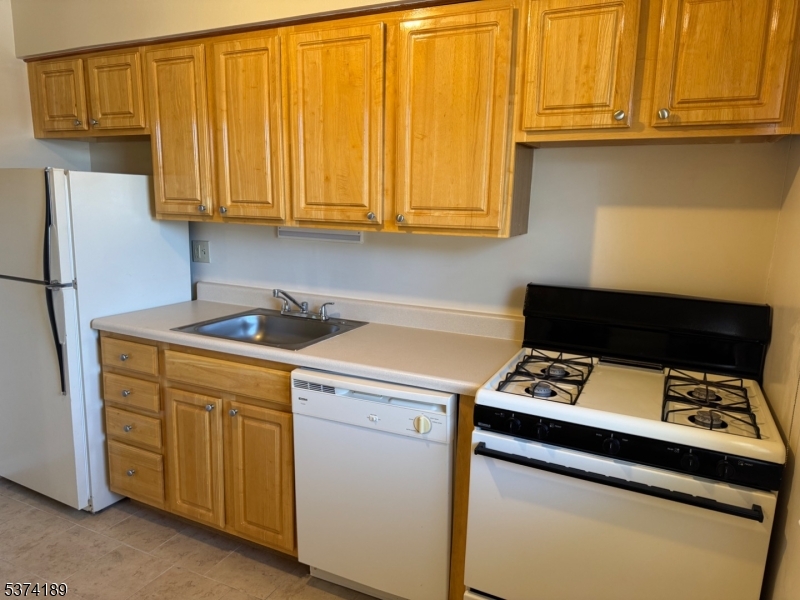 1298 Valley Road, Unit 1 Wayne, NJ 07470 - Photo 14 of 18 a kitchen with stainless steel appliances a stove a microwave and white cabinets