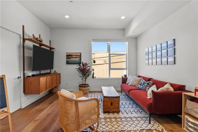 a living room with furniture a flat screen tv and a window
