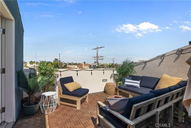 a roof deck with couches and potted plants