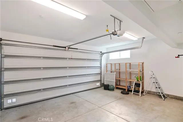 a view of a room with gym equipment and a chandelier