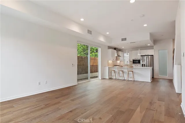 a view of a kitchen with furniture and wooden floor