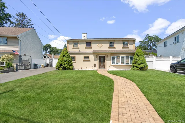 a front view of a house with a garden and plants