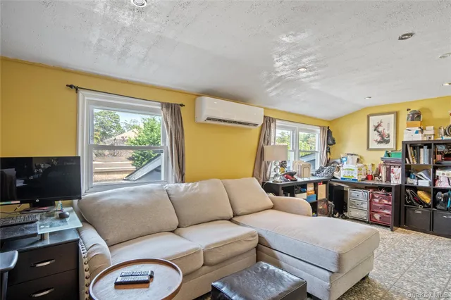 a living room with furniture a flat screen tv and a window
