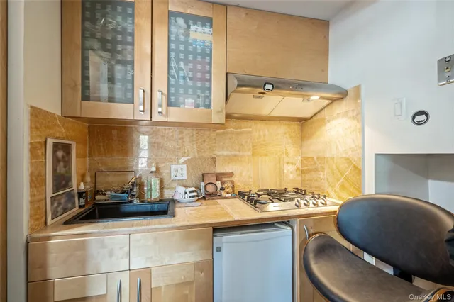 a bathroom with a granite countertop sink a toilet a mirror and shower